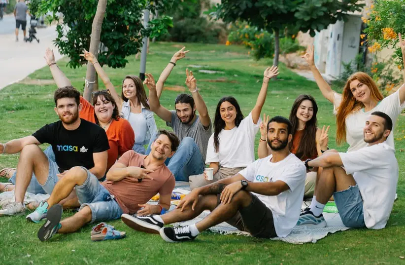 חבורת צעירים יושבת על הדשא